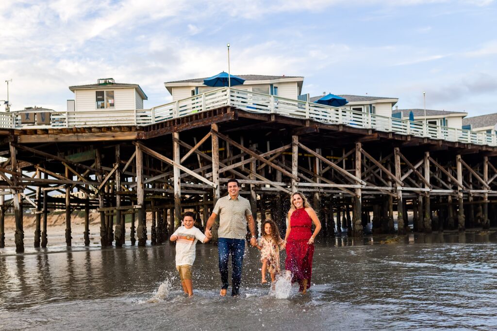 Family splashing in the water at Crystal Pier in San Diego
