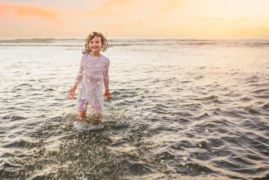Girl splashing in water at San Diego beach