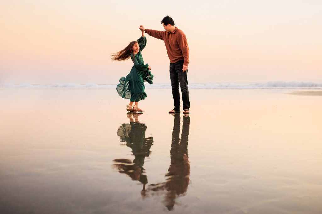 Father and daughter dancing at the beach, taken by Loni Brooke Photography in San Diego
